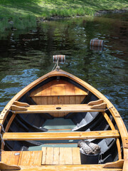 A wooden rowboat seen from above as it bobs on the water.