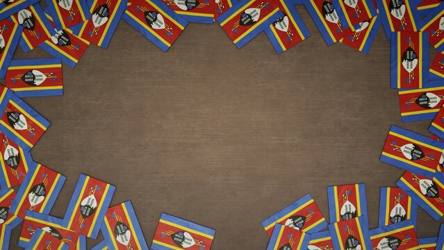 Frame made of paper flags of Eswatini arranged on wooden table. National celebration concept. 3D illustration