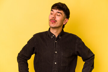 Young caucasian man isolated on yellow background dreaming of achieving goals and purposes