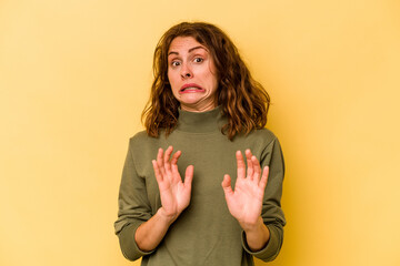 Young caucasian woman isolated on yellow background rejecting someone showing a gesture of disgust.