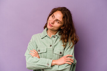 Young caucasian woman isolated on purple background dreaming of achieving goals and purposes