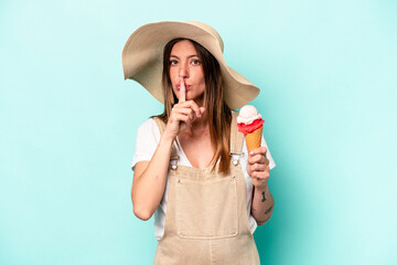 Young caucasian pregnant woman holding an ice cream isolated on blue background keeping a secret or asking for silence.