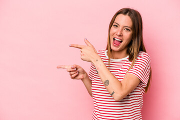 Young caucasian pregnant woman isolated on white background excited pointing with forefingers away.