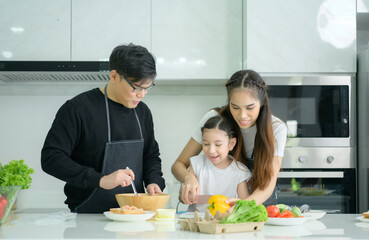 Asian family They are having cooking together happily in the kitchen room of the house.