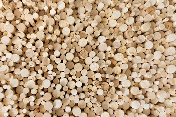 Textured background of round wooden bars. Smooth wooden rods of different diameters for texture. A wall of timber cylinder bars without bark