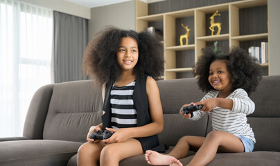 Two brothers of an Asian-African American family. Relax and play online games in the living room of...