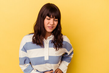 Young caucasian woman isolated on yellow background having a liver pain, stomach ache.