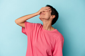 Young caucasian woman isolated on blue background laughs joyfully keeping hands on head. Happiness concept.