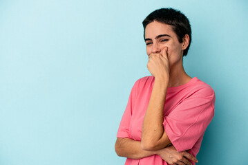 Young caucasian woman isolated on blue background laughing happy, carefree, natural emotion.