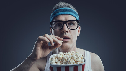Funny guy watching movies and eating popcorn