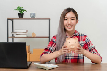 Young Asian businesswoman is saving money from doing business online.