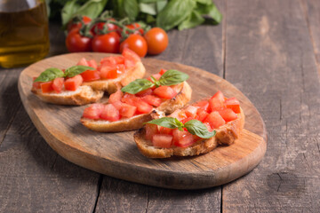 Tomato and basil fresh made bruschetta. Italian tapas, antipasti with vegetables, herbs and oil on grilled ciabatta and baguette bread. Sandwich.