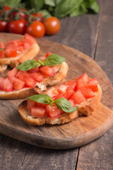 Tomato and basil fresh made bruschetta. Italian tapas, antipasti with vegetables, herbs and oil on grilled ciabatta and baguette bread. Sandwich.