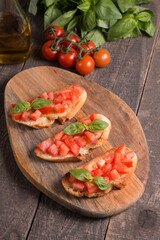 Tomato and basil fresh made bruschetta. Italian tapas, antipasti with vegetables, herbs and oil on grilled ciabatta and baguette bread. Sandwich.