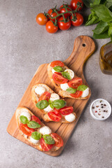 Tomato, basil and cheese fresh made caprese bruschetta. Italian tapas, antipasti with vegetables,...