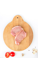 Raw steaks in row with spices on wooden board, top view, overhead, flat lay.