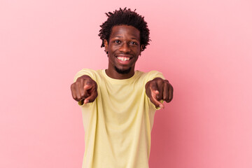 Young african american man isolated on pink background cheerful smiles pointing to front.
