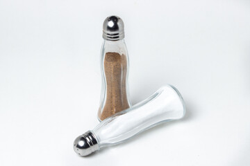 Salt and pepper shaker on a white background. Glass transparent salt shakers