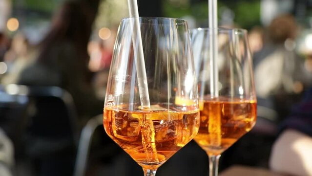 Zwei Gl&auml;ser Mixgetr&auml;nk Cocktail Spritz in einem Biergarten im Sommer