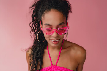 attractive black african american woman in stylish outfit on pink background