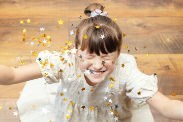 Portrait of a pretty girl with star-shaped sequins on her face. The girl smiles. Fun holiday, party...