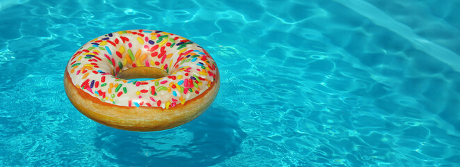 Bright inflatable doughnut ring floating in swimming pool on sunny day, space for text. Banner design