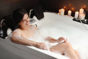 Happy beautiful woman taking bubble bath. Romantic atmosphere