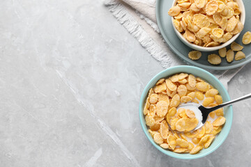 Tasty cornflakes with milk served on light grey table, flat lay. Space for text