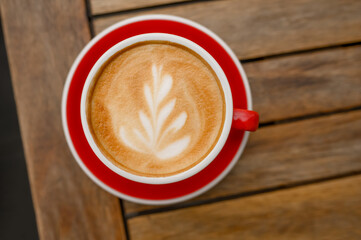 Cup of aromatic coffee on wooden table, top view