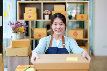 Portrait of a business woman, sme packing products in boxes and showing delivery to customers according to their orders
