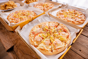 Freshly baked pizza just out of the oven on a wooden board.