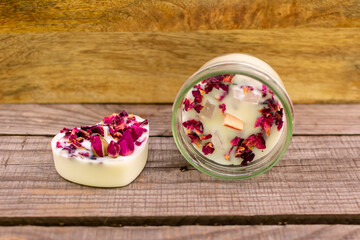 Kerze mit Holzdocht Rosenblättern und Rosenquarzsteinen im Schraubglas