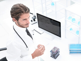 scientific researcher looking at a test tube of blue liquid