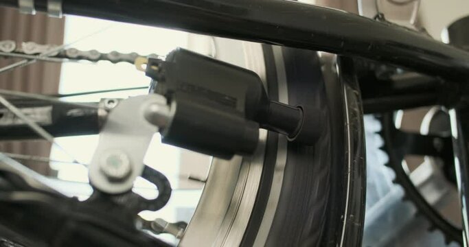 Production electricity through bicycle dynamo machine. Spin the wheel on the tire. Dynamo slow motion, close-up.