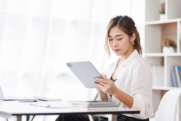 Cropped shot of Asian woman hand working on laptop computer while sitting at the table in office room, vertical view.