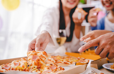 hands of a colleague or friend eating pizza After meeting at the office for a long time They're...