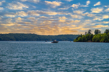 a motor boat sailing across the rippling blue waters of Lake Allatoona surrounded by lush green...