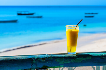 Juice of pineapple and orange. Ocean at the background