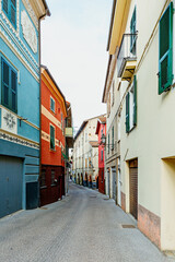 Fototapeta na wymiar Narrow colored street in the city of Albenga. Italy