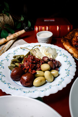 a plate of olives, cucumbers, sun-dried tomatoes and vegetables