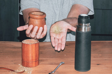 Hand with yerba powder, steps to prepare mate, traditional Argentine drink.