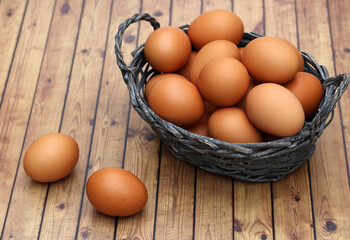 Ein Korb mit Bio Eiern auf rustikalem Holzhintergrund.