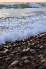 foamy waves and smooth wet pebbles