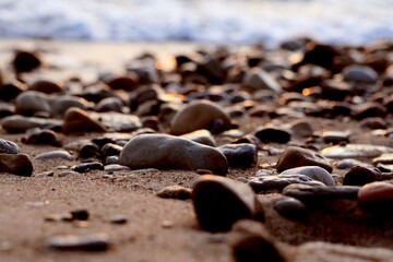 Fototapeta na wymiar foamy waves and smooth wet pebbles