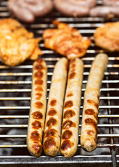 Tasty and delicious traditional German sausages and steaks over the hot coals. Barbecue BBQ or summer garden party concept. Selective focus.