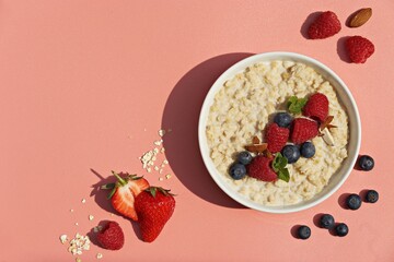 Oatmeal porridge with fresh berries. National Porridge Day, banner. Creative flt layot.