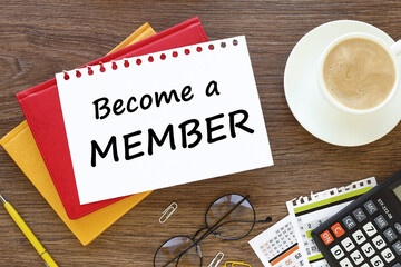 coffee cup glasses wooden background. Top angle view of pen and notebook written with text BECOME A MEMBER. Business and education concept.