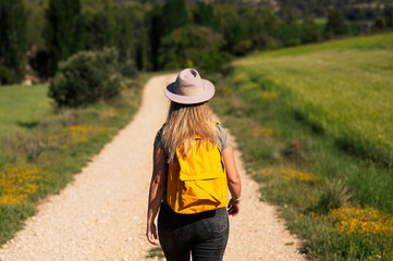 Traveler woman walking on the road with backpack on her back.