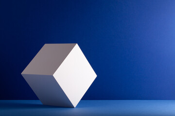 White cube in balance on a blue background.