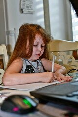 Child girl first grader to study remotely during the war in Ukraine.